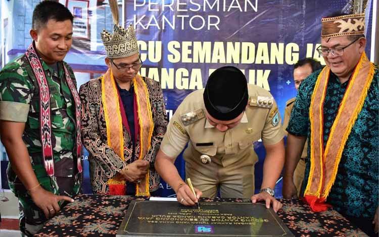 Bupati Lamandau Hendra Lesmana menandatangani prasasti saat acara peresmian gedung baru CU Semandang Jaya Nanga Bulik. (FOTO : HENDI NURFALAH)