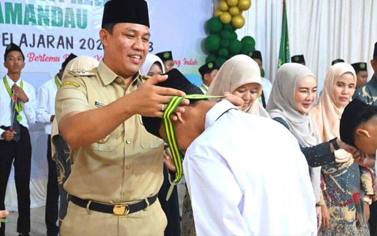 Bupati Hendra Lesmana memberikan kalung wisuda kepada salah satu pelajar MTs Negeri Lamandau. (FOTO : HENDI NURFALAH)