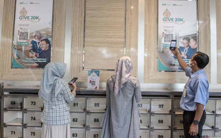 Warga memindai QRIS saat membayar donasi secara digital di Masjid BSI Wisma Mandiri, Jakarta, Selasa (11/4/2023). ANTARA FOTO/Muhammad Adimaja/rwa.