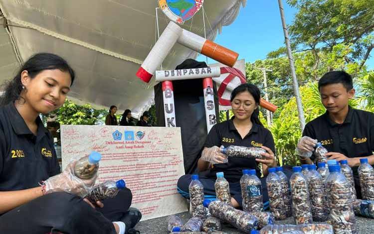 Anggota FAD Denpasar saat mengumpulkan puntung rokok dalam botol di Denpasar, Bali, Selasa (25/4/2023). ANTARA/HO-FAD Denpasar