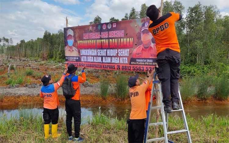 Personel BPBD Kapuas saat pasang spanduk imbauan cegah karhutla di titik rawan terjadinya karhutla. (FOTO: IST)