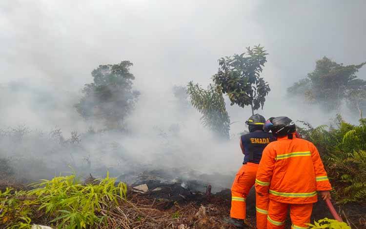 Petugas pemadam kebakaran saat memadamkan api di lokasi kebakaran lahan dan hutan di Jalan Wengga Metropolitan. Rabu, 14 Juni 2023. (FOTO: BUDDI)