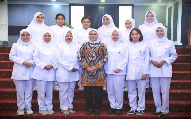 Menteri Ketenagakerjaan Ida Fauziyah (tengah) berfoto bersama dengan pekerja migran Indonesia (PMI) yang akan bekerja sebagai perawat di Singapura. (ANTARA/HO-Kemnaker)
