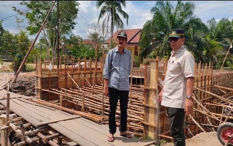 Wakil Ketua II DPRD Kobar Bambang Suherman (kanan) bersama Wakil Ketua I Mulyadin meninjau pembangunan jembatan. (Foto: ISTIMEWA)