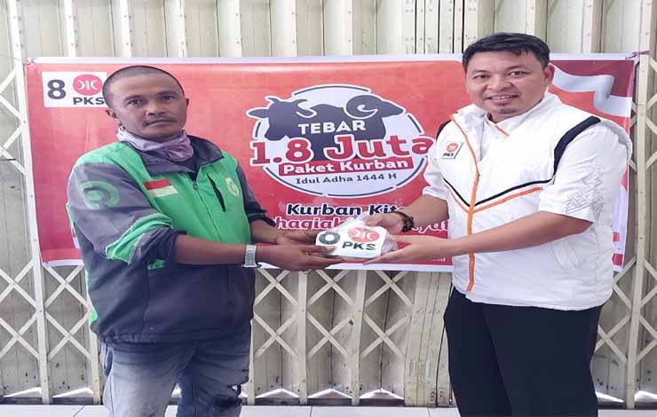 Pengurus PKS Kalteng, Heru Hidayat menyerahkan daging kurban kepada salah satu ojek online di Kota Palangka Raya, Jumat 30 Juni 2023
