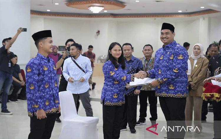 Anthony Sinisuka Ginting (kiri) dan Felda Elvira Santoso (tengah) menerima SK pengangkatan PNS Kemenpora dari Menteri Pemuda dan Olahraga Dito Ariotedjo (kanan) pada upacara pengambilan sumpah dan janji Pegawai Negeri Sipil, di Auditorium Kemenpora, Jakarta, Selasa (5/7/2023). (ANTARA/HO/Kemenpora)