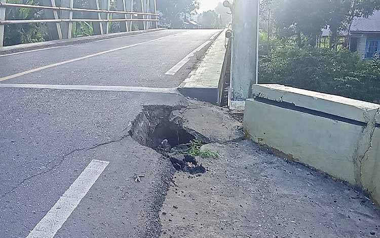 Lubang sepanjang hampir satu meter di ujung sisi selatan Jembatan Sungai Paku RT 03 Desa Tampa Kabupaten Barito Timur. (FOTO: IST)