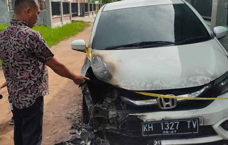 Pemilik mobil, Fitriadi, pada saat menunjukkan bagian mobilnya yang terbakar (Foto : Pathur)