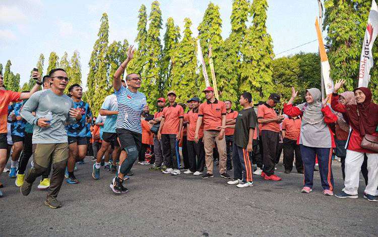 Menparekraf sekaligus Ketua Bapppilu PPP Sandiaga Uno menyapa warga yang bertemu dengannya di sepanjang rute dia bersama jajaran Forkopimda Ponorogo lari-lari di seputar Kota Ponorogo, Minggu (16/7/2023) (ANTARA/HO - Foto warga)