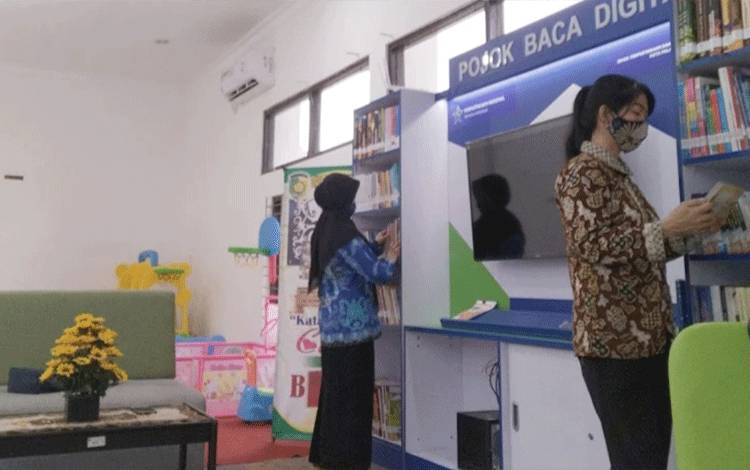 Pengunjung MPP Huma Betang Palangka Raya membaca buku sambil menunggu antrean pelayanan. (FOTO: HENDRI)