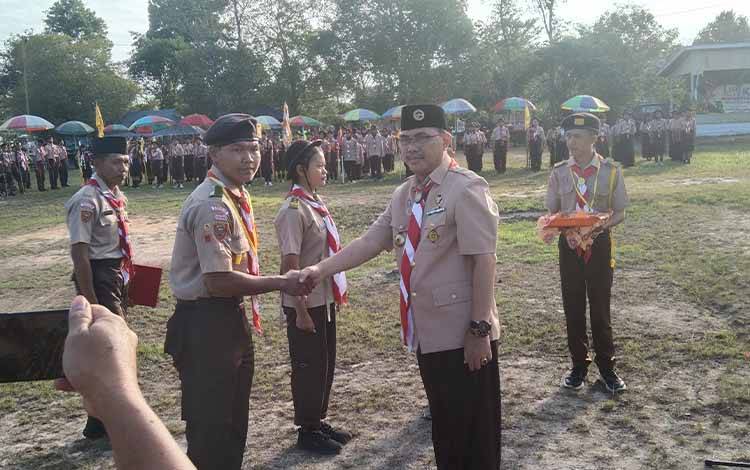 Ketua Kwartir Cabang 1508 Katingan, Sunardi Litang menyalami peserta kemah besar.
