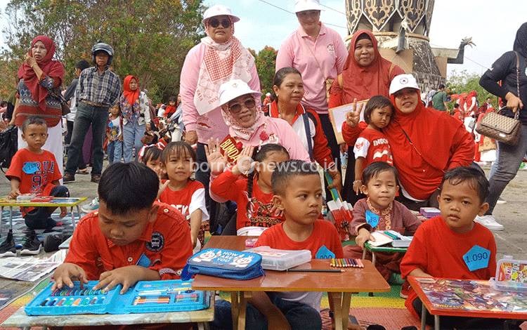 Bunda PAUD Kotawaringin Timur Khairiah Halikinnor bersama anak-anak yang mengikuti lomba mewarnai dalam rangka memperingati hari anak nasional, Minggu, 6 Agustus 2023. (FOTO: DEWIP)?