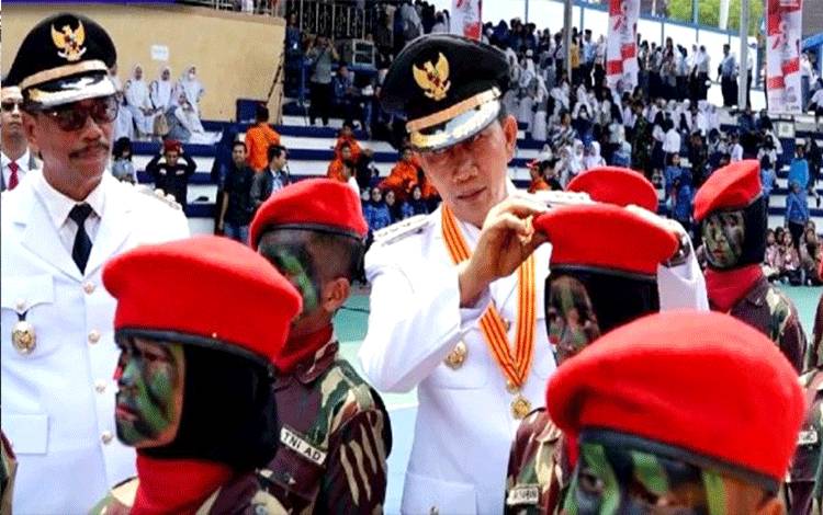 Bupati Barito Utara Pungut dan Pasangkan Kembali Baret Merah yang Terjatuh di Lapangan