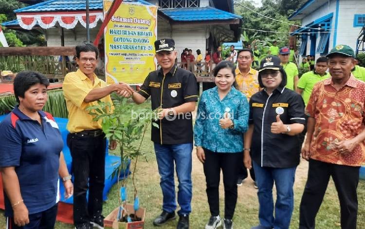 Bupati Gunung Mas Jaya S Monong saat menyerahkan bibit pohon kelengkeng kepada warga dari rencana aksi Dinas Pertanian setempat di kegiatan BBGRM, Selasa, 22 Agustus 2023. (FOTO: IST)