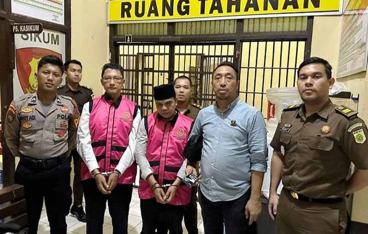 Kedua tersangka mengenekan rompi tahanan diapit petugas Kejari Lamandau dan Polres Lamandau di ruang tahanan. (FOTO : HENDI NURFALAH)