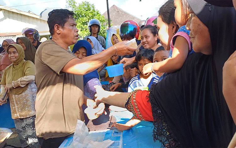 Warga berebut bubur baayak Gratis di Jalan Ir H Juanda, Kecamatan Mentawa Baru Ketapang, Kabupaten Kotawaringin Timur, Rabu, 13 September 2023. (FOTO: DEWIP)