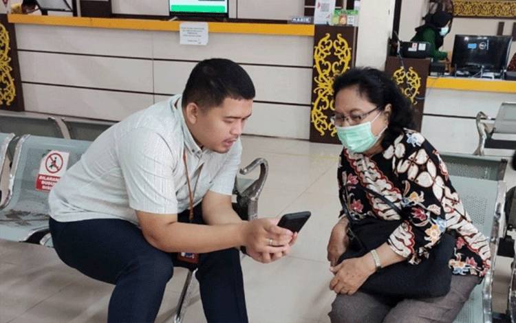 Seorang warga di Kota Palangka Raya mendaftarkan diri sebagai peserta BPJS Kesehatan dengan dibantu petugas BPJS Kesehatan.(FOTO: Dokumentasi BPJS Kesehatan)