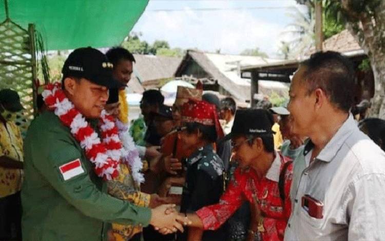 Bupati Lamandau Hendra Lesmana menyalami sejumlah tokoh masyarakat saat melaksanakan kunjungan kerja ke Desa Sungai Buluh, Kecamatan Belantikan Raya. (FOTO : HENDI NURFALAH)