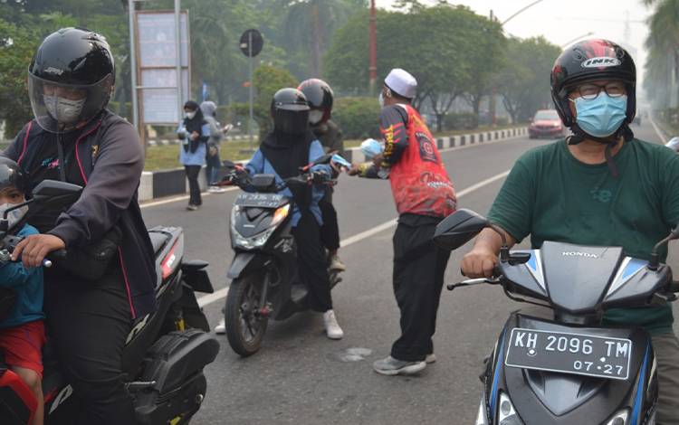 Dinsos Kalteng Bagikan Masker ke Pengguna Jalan