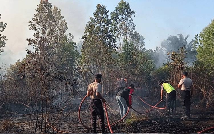 Anggota Polres Sukamara saat berupaya melakukan pemadaman kebakaran. (FOTO: NORHASANAH)