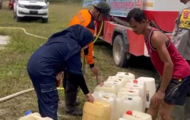 Personel BPBD Lamandau bersama Karang Taruna salurkan air bersih kepada warga terdampak kekeringan akibat kemarau panjang. (FOTO : HENDI NURFALAH)