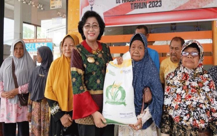 Pj Bupati Lilis Suriani menyalurkan?bantuan pangan cadangan beras pemerintah?kepada keluarga penerima manfaat di Nanga Bulik. (FOTO : HENDI NURFALAH)