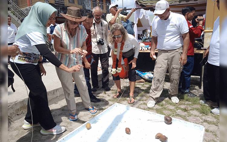 Para wisatawan dikenalkan permainan gasing yang termasuk budaya olahraga tradisional dari Kabupaten Kobar, Kalimantan Tengah di Sail To Indonesia 2023, Sabtu, 21 Oktober 2023 (FOTO: NURITA)