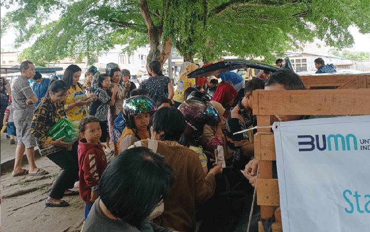 Masyarakat Kuala Kurun bergerombol antre membeli bahan pangan yang dijual di pasar penyeimbang yang digelar oleh Dinas Perikanan dan Ketahanan Pangan Kabupaten Gunung Mas, Kamis, 9 November 2023. (FOTO: RISKA YULYANA)