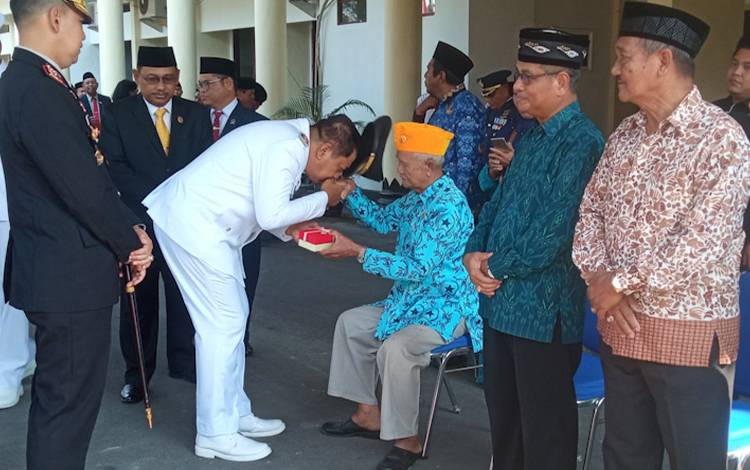 Pj Bupati Kobar Budi Santosa saat menyalami salah seorang anggota Legiun Veteran dalam peringatan ke 78 Hari Pahlawan, Jumat, 10 November 2023.