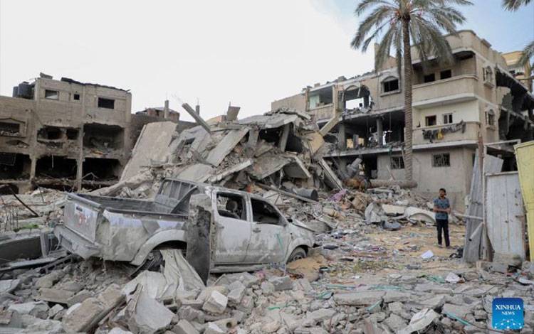 Seorang warga berdiri di antara reruntuhan bangunan-bangunan yang hancur akibat serangan Israel di Kota Khan Younis di Jalur Gaza bagian selatan pada Ahad (12/11/2023). ANTARA/Rizek Abdeljawad/Xinhua/tm