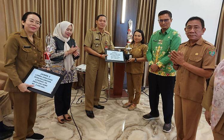 Staf Ahli Gubernur Yuas Elko mewakili Gubernur Kalteng menyerahkan penghargaan kepada pemenang Desa/Kelurahan Literasi. (FOTO:RENNY)