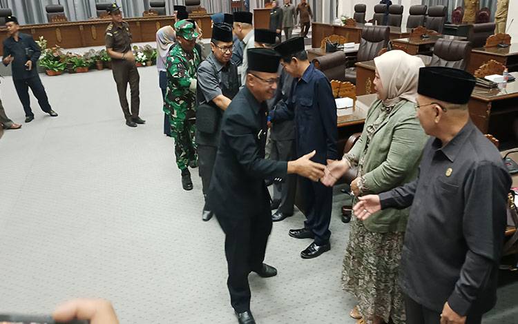 Plt Sekda Kabupaten Barito Utara, Drs Jufriansyah salami anggota DPRD Barito Utara saat akan meninggalkan ruang rapat paripurna DPRD.(foto: Dhani)