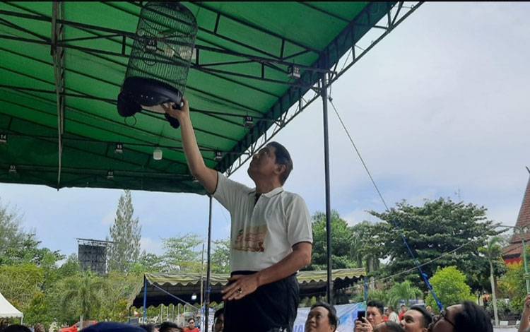 Pj Bupati Kobar Budi Santosa saat menggantungkan sangkar burung sebagai tanda dimulainya lomba burung berkicau DPRD Cup III. (FOTO: DANANG)