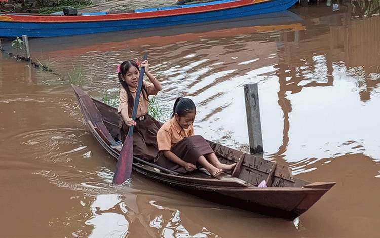 Murid SD di Kelurahan Kameloh Baru Bersekolah dengan Perahu Akibat Banjir