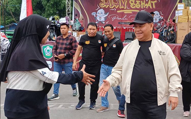 Bupati Kotawaringin Timur Halikinnor bersalaman dengan seorang warga. (FOTO: DEWIP)