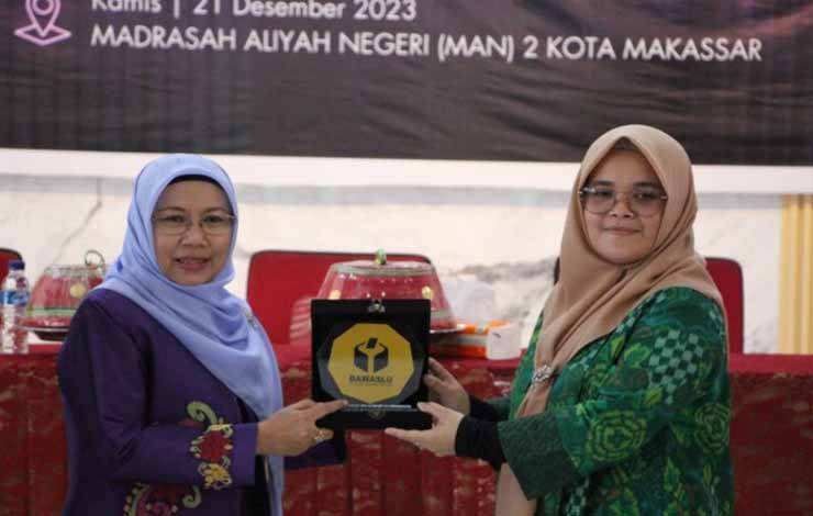 Anggota Bawalsu RI Lolly Suhenty (kanan) menerima plakat dari Kepala Sekolah MAN 2 Kota Makassar Darmawati (kiri) disela peluncuran Madrasah Anti Hoaks di Sekolah Madrasah Aliayah Negeri (MAN)2 Makassar, Sulawesi Selatan, Kamis (21/12/2023). ANTARA