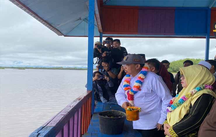 Pj Bupati Sukamara, Kaspinor menyiramkan air bunga yang telah diberikan doa-doa keluar, Kamis, 11 Januari 2023. (FOTO:NORHASANAH)