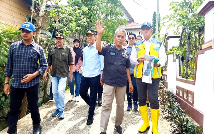 Pj Bupati Barito Utara, Muhlis didampingi Kadis PUPR, Camat Teweh Tengah bersama tim dari Direktorat Jenderal Sumber Daya Air (Dirjen SDA) Direktorat Bina Operasi dan Pemeliharaan (OP) Kementrian Pekerjaan Umum dan Perumahan Rakyat (PUPR) saat meninjau beberapa titik banjir di daerah setempat, salah satunya di belakang kantor BappedaLitbang, pada Minggu 21 Januari 2024.(foto: Dhani)