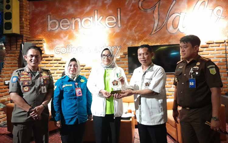 Pj Wali Kota Palangka Raya Hera Nugrahayu saat menerima plakat dari kepada Ketua PWI Kalteng Zainal (Foto : IST)