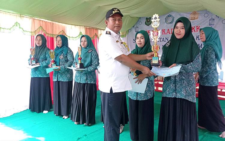 Camat Kapuas Kuala, Nurcahyono saat serahkan piala kepada pemenang lomba maulid habsyi usai pertemuan rutin TP PKK sekecamatan. (FOTO: IST)