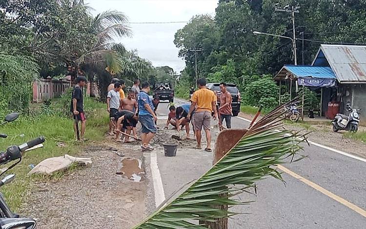 Warga RT 03 Desa Kupang Baru Swadaya Cor Jalan Provinsi Berlubang