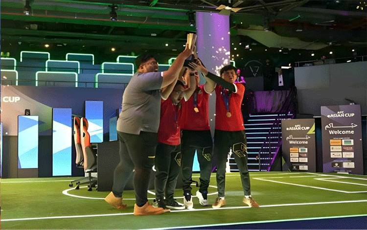 Tangkap layar tim nasional eFootball Indonesia mengangkat trofi usai memastikan diri sebagai juara AFC eAsian Cup Qatar 2023 di Virtuocity Arena Doha, Qatar, Minggu (5/2/2024). (ANTARA/Arindra Meodia/youtube.com/AFC Asian Cup)