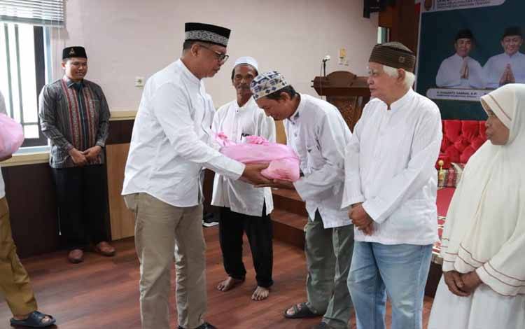 Kadislutkan Provinsi Kalteng H. Darliansjah saat menyerahkan secara simbolis paket sembako dalam rangkaian peringatan Isra Miraj. (FOTO: IST)
