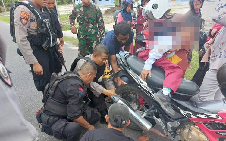 Personel keamanan yang sedang patroli membantu melepaskan kaki seorang anak yang terjepit rantai motor saat dibonceng ibunya ketika melintas di jalan depan perumahan TNI AU, Selasa, 13 Februari 2024.