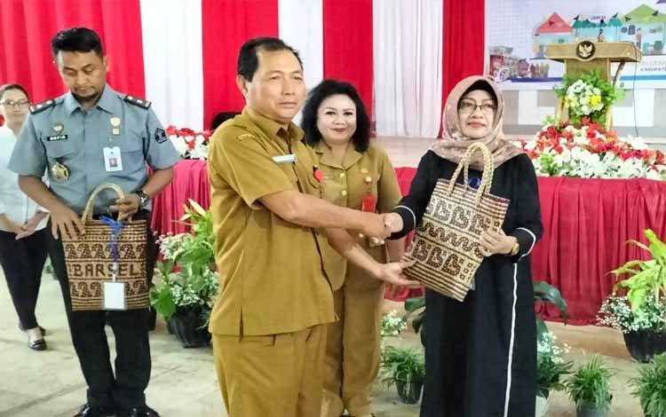 Asisten III Setda Barsel, Mirwansyah didampingi Kadis Perindagkop Swita Minarsih memberikan cinderamata. (URIUTU)