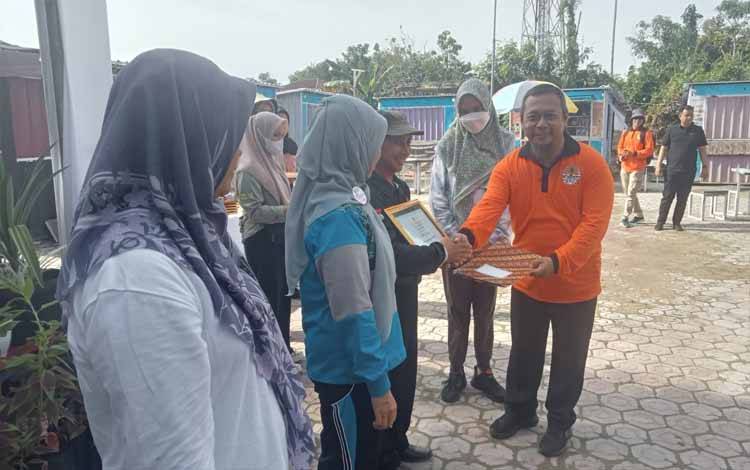 Kepala DLH Sukamara, M Fakhmi Rizali memberikan penghargaan pada peringatan Hari Peduli Sampah Nasional (HPSN) di Pasar Saik, Jumat, 1 Maret 2024. (FOTO : NORHASANAH)