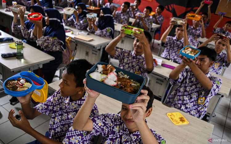 Sejumlah siswa menunjukkan makanan gratis saat simulasi program makan siang gratis di SMP Negeri 2 Curug, Kabupaten Tangerang, Banten, Kamis (29/2/2024). (ANTARA FOTO/Sulthony Hasanuddin)