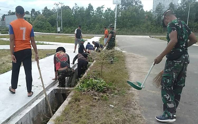 Sejumlah personal Babinsa 1017-02/Lamandau kerja bhakti membersihkan parit. (FOTO : HENDI NURFALAH)