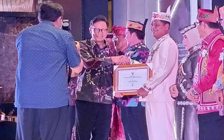 Pj Bupati Seruyan Djainuddin Noor ketika menerima sertifikat bebas Frambusia dari Kementerian Kesehatan. (FOTO : PROKOM SERUYAN)