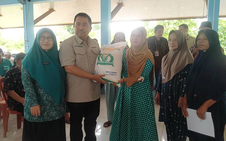 Pj Bupati Sukamara, Kaspinor berfoto bersama usai penyerahan bantuan sosial Cadangan Pangan Pemerintah (CPP) secara simbolis di Kelurahan Mendawai pada Sabtu, 9 Maret 2024. (FOTO : NORHASANAH)